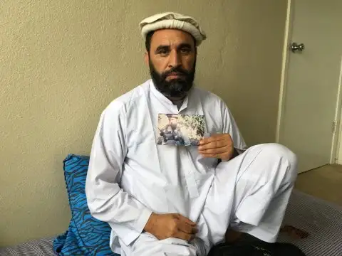 穆罕默德·古拉布在德克萨斯州沃斯堡的公寓里，手持卢特雷尔的照片