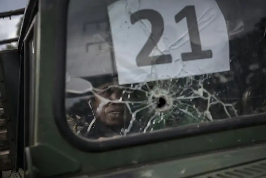 士兵站在布满弹孔的车辆挡风玻璃后，准备撤离战场