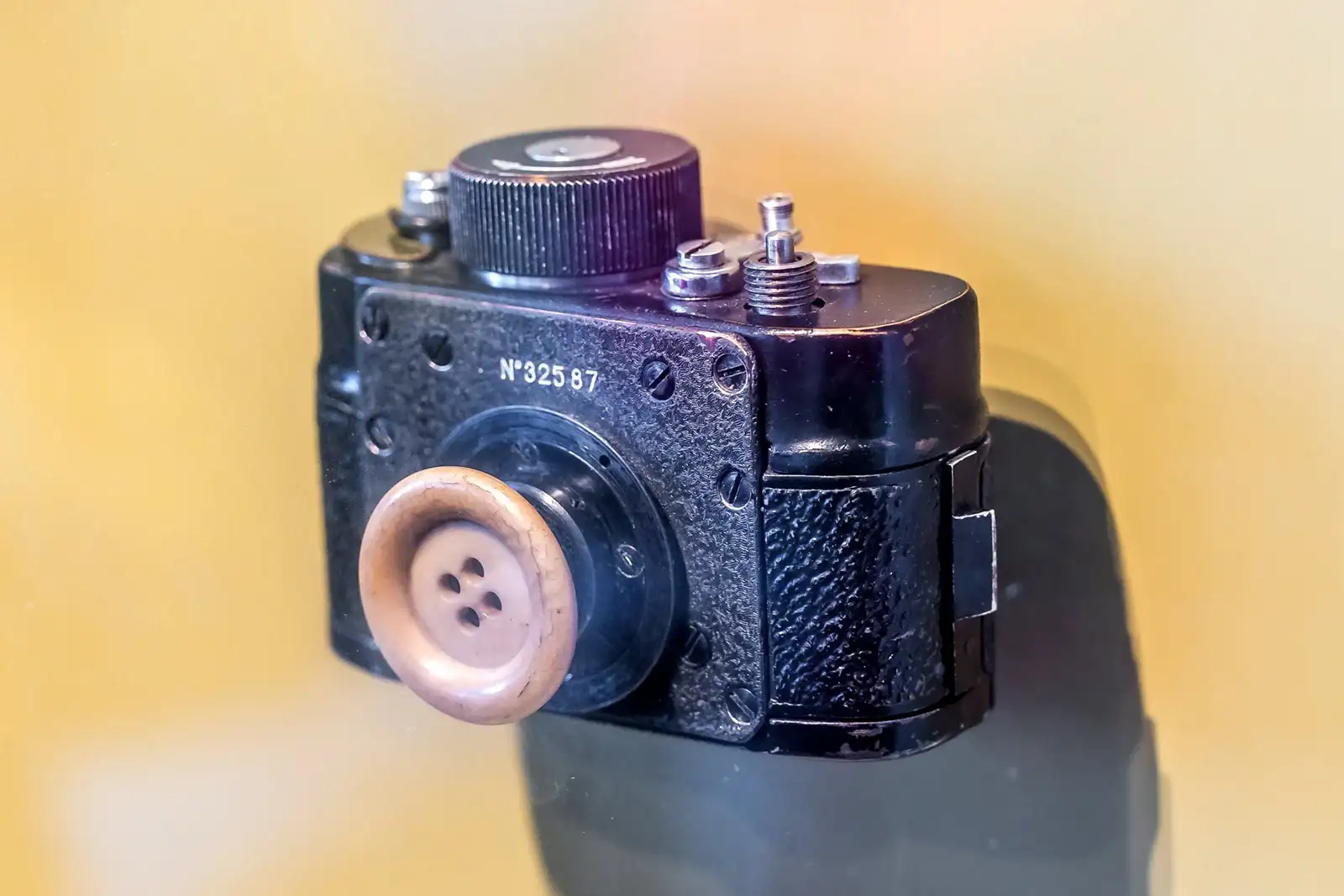 苏联制造的F-21微型相机，克格勃从1950年代开始装备，深受斯塔西青睐。它可以隐藏在纽扣、皮带、钱包等日常物品后面。