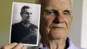 卡廷大屠杀受害者家属Franciszek Herzog，手持父亲的照片，父亲在卡廷大屠杀中遇难