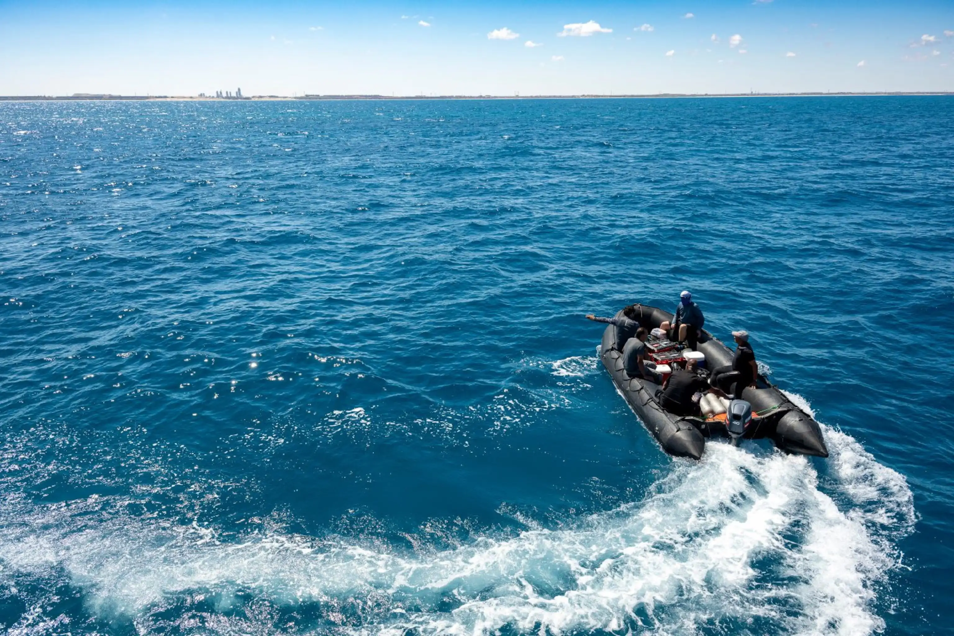 探险队成员乘坐充气艇前往水下探索地点