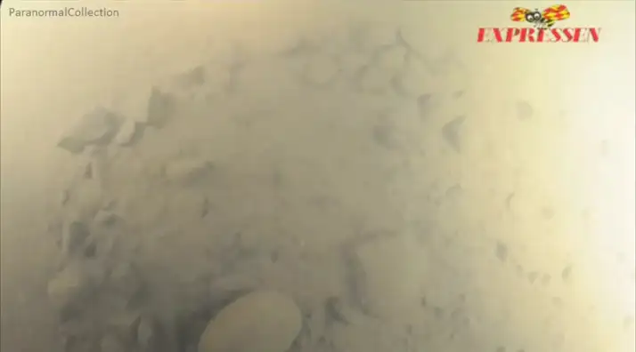 异常物体表面的岩石照片，显示黑色烧焦痕迹