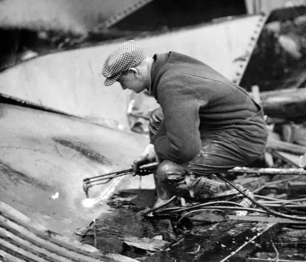 工人正在切割储罐残骸搜寻遗体