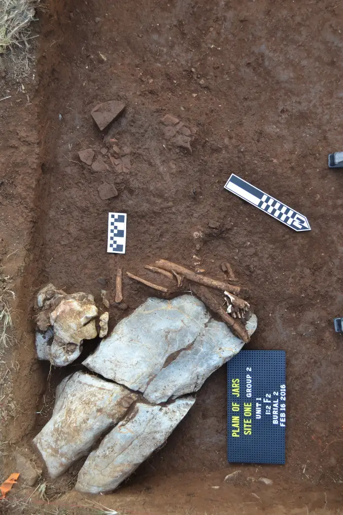 二号遗址发现的二次埋葬，骨骼与石灰岩块相关联，位于砂岩圆盘下方