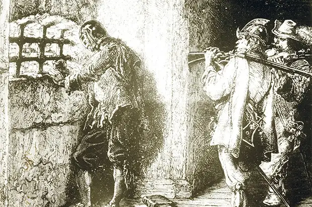 铁面人在狱中，由两名火枪手看守，准备在他摘下面具时杀死他